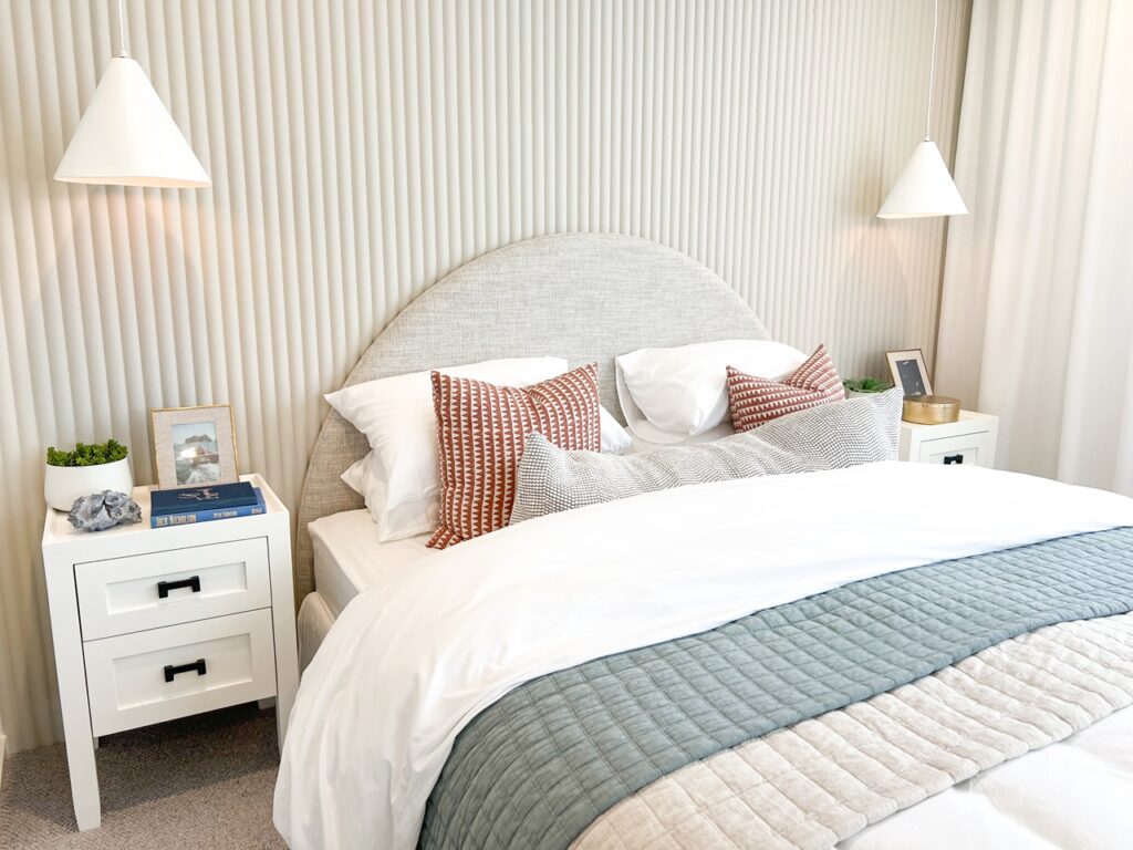create an inviting bedroom sancturay, styled bed and bedside tables in soft neutral tones